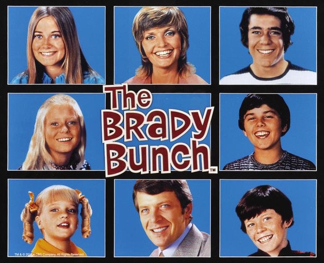 Henderson as Carol Brady, in the upper row's center square, with the members of her TV family